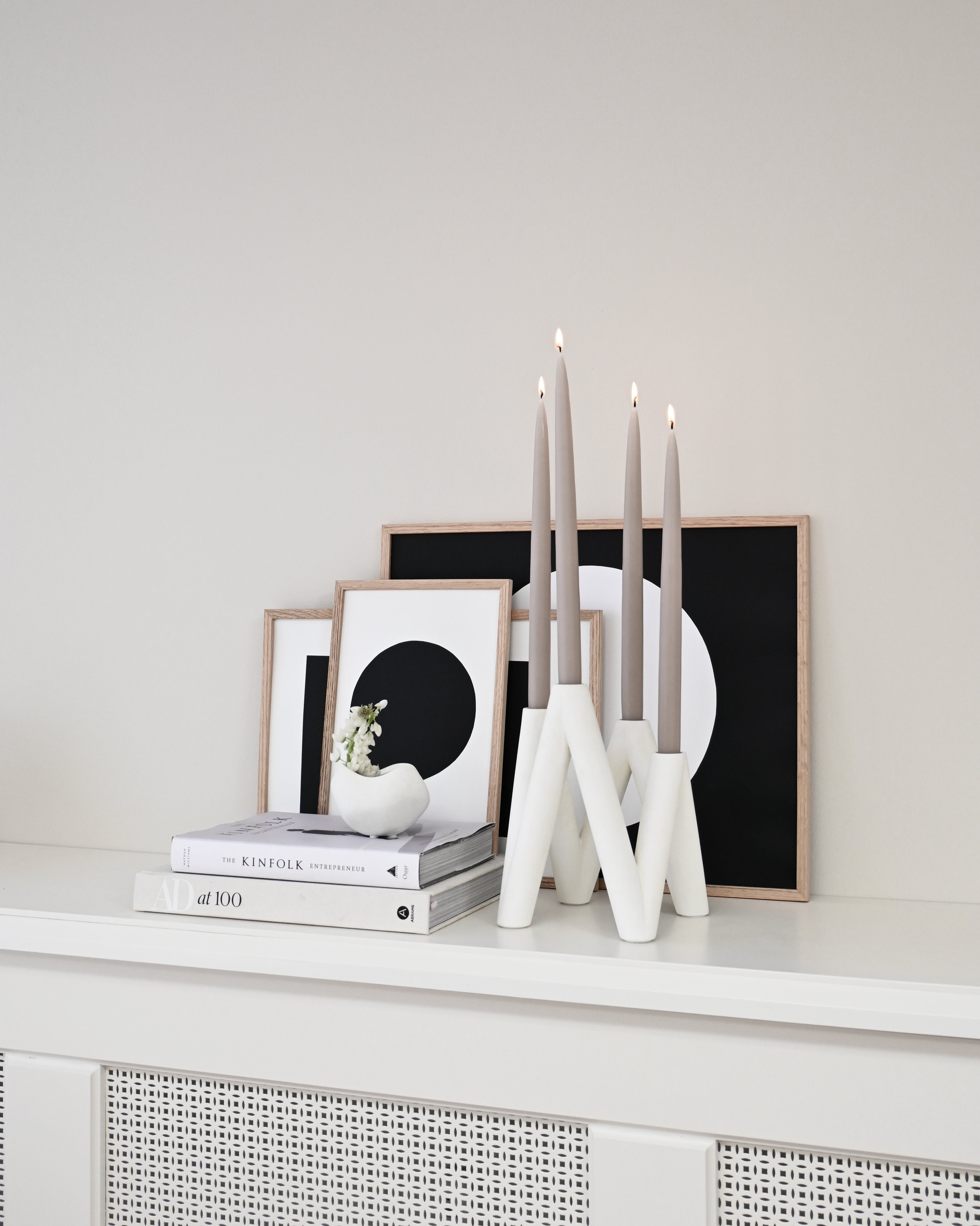 W Candle Holder - Bone White with lit candles by books and framed images