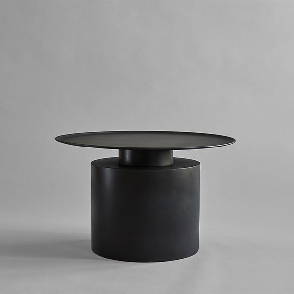 Burned Black cylindrical Low Pillar side table on a gray background