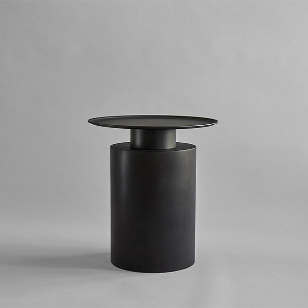 Burned Black cylindrical Tall Pillar side table on a gray background