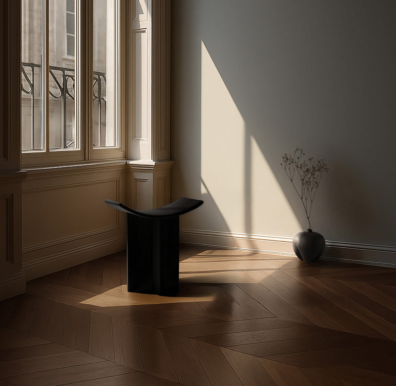 Modern Brutus stool in a sunlit room with wooden floor and large windows.